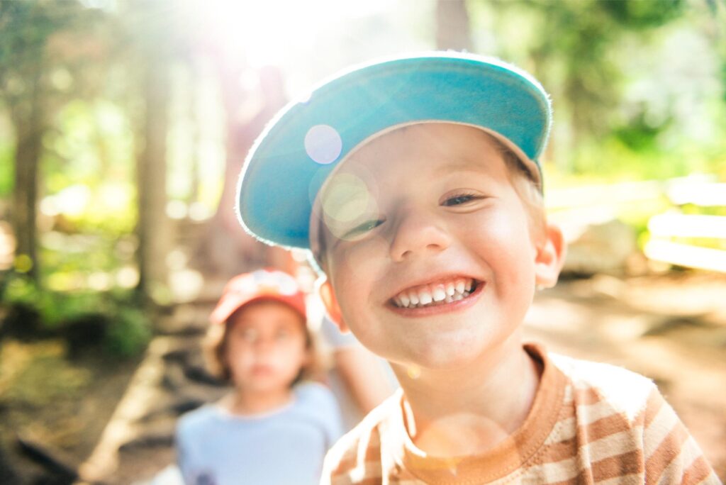 Smiling young child in a blue cap outdoors, illustrating a Lafayette parent's guide to palatal expanders for kids